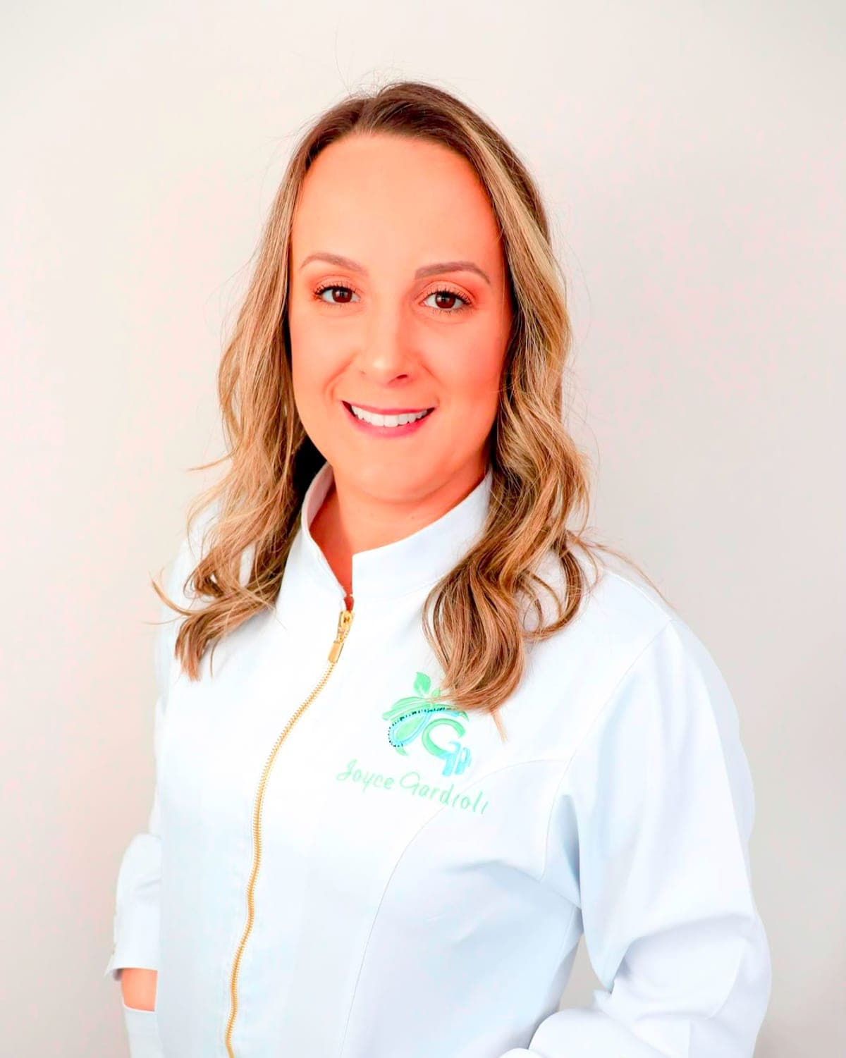 Joyce Gardioli, nutricionista, de jaleco branco com o logo bordado